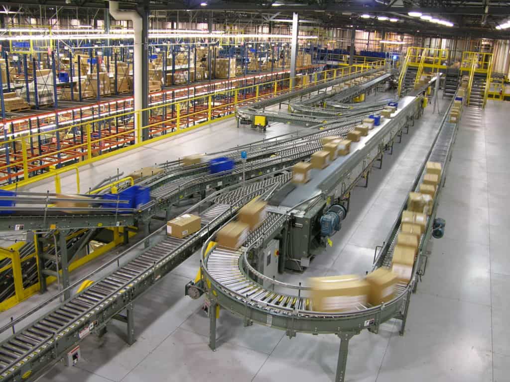Accumulation Conveyor: Zero-Pressure vs. Minimum-Pressure, and How to Choose 4 Curved roller conveyor lines carrying cartons across the main floor of the Barnes & Noble distribution center