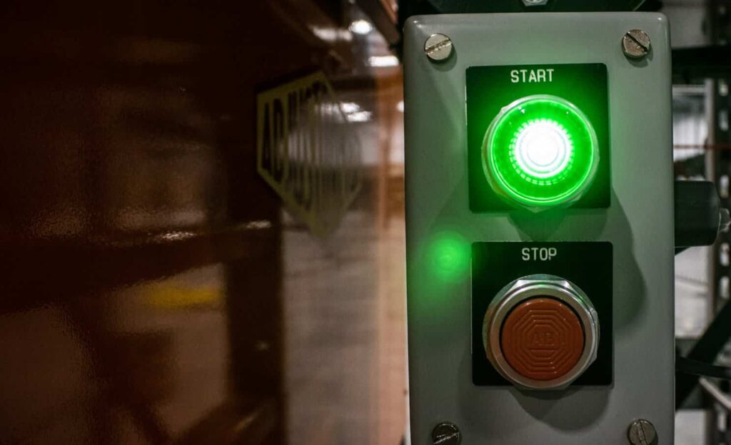 Conveyor Safety: Guarding, E-Stops, Pull Cords, and Lockout/Tagout 2 Green START and red STOP push-button control station, part of the conveyor safety controls on a line installed by Century Conveyor